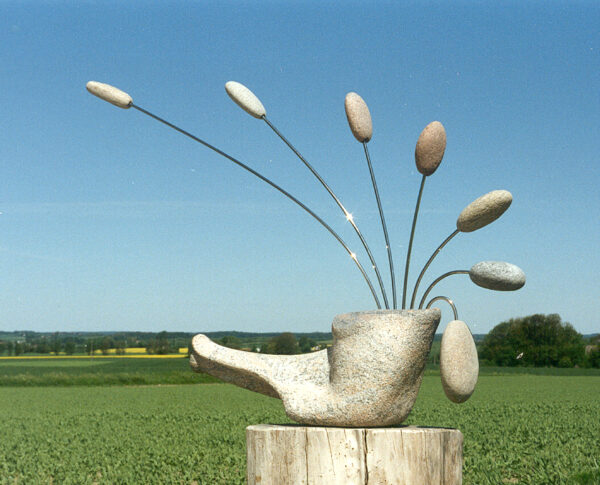 Vindfølsom vogter (1997). Mobile. Granit, strandsten, rustfrit fjederstål. Ca. 140 cm x 100 cm x 30 cm.