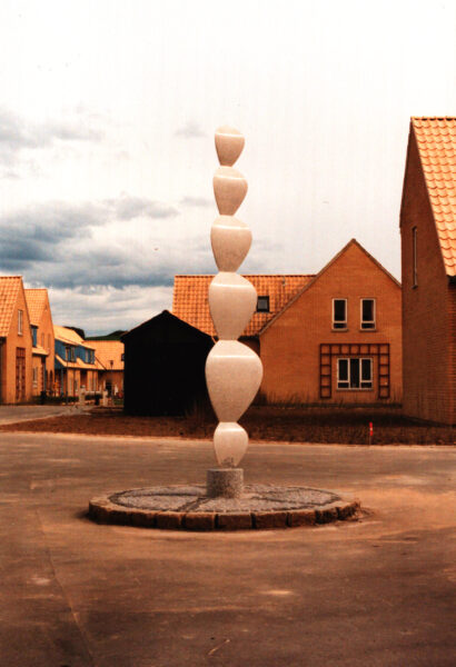 Phigur (1991). Kunststen af Synopal. Højde ca 2,5 meter. Boligforeningen Håndværkerparken, Højbjerg, Århus. Værkets flader, former og proportioner har konstanten Phi som geometrisk grundelement.