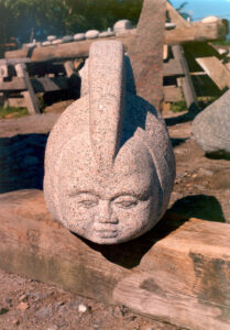 Puppe (1988). Granit. En af de fem figurer til udsmykingen Aflejringer fra fritiden. Børglumparken, Boligselskabet Fruehøjgaard, Herning.