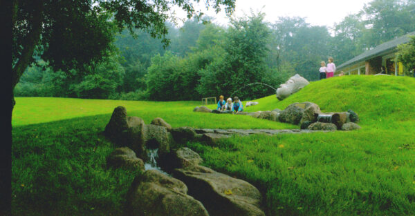 Skovbakketrolden (1987). Springvand. Granit. Fotograferet på springvandets oprindelige plads. Vandet løb gennem en lang rende bygget af kampesten med vandfald. Værket blev senere flyttet til åen ved Odder Rådhus.