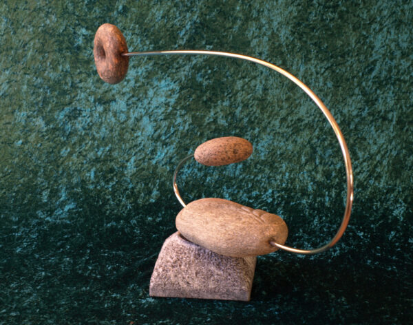 Springfyr (2022). Granit, strandsten, rustfrit fjederstål, magneter. Højde 41cm. Længde 81cm. Diameter ved rotation max 100cm.