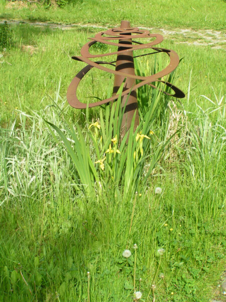 Stålstræk på gammel præstepik (2002). Højde 120 cm. Diameter 95 cm. Strakt cortenstålplade placeret på en præstepik (faglig betegnelse for et konisk smedeværktøj).