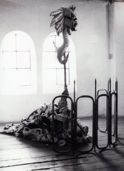 Vesteuropæisk Mareridt (1980). Assemblage. Lerfigur på sokkel af diverse plast-, metal- og papirskrammel. Højde 1,5 meter. Her fotograferet i Gallopperiet, Christiania, 1983.